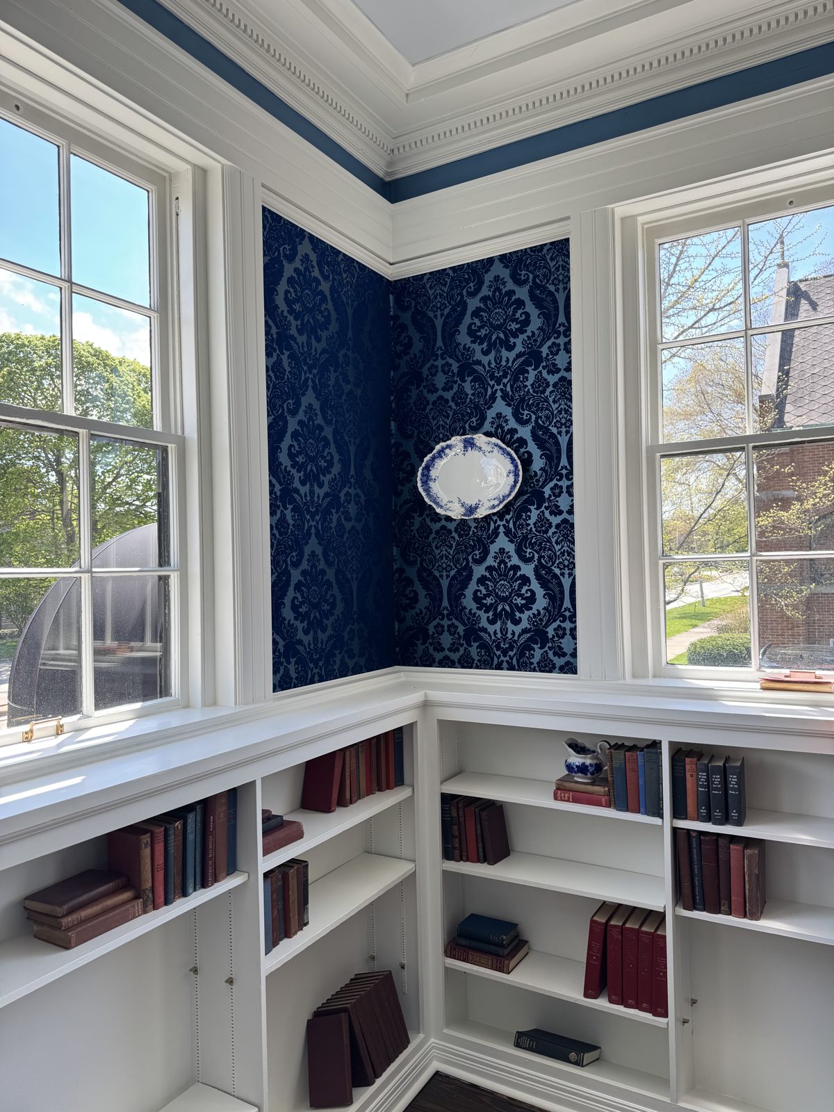 Finished suite with navy damask wallpaper and built-in shelves