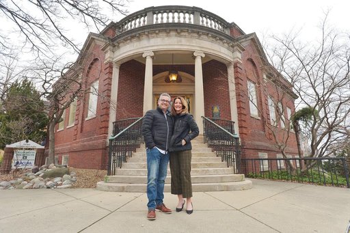 The Library Historic Hotel exterior — owners Shannon Kutchek and John Kenna in front of the restored 1903 Carnegie Library, St. Joseph, MI
